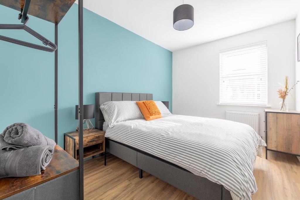 een slaapkamer met een bed en een blauwe muur bij Bliss Stay Belfast: The Mount in Belfast