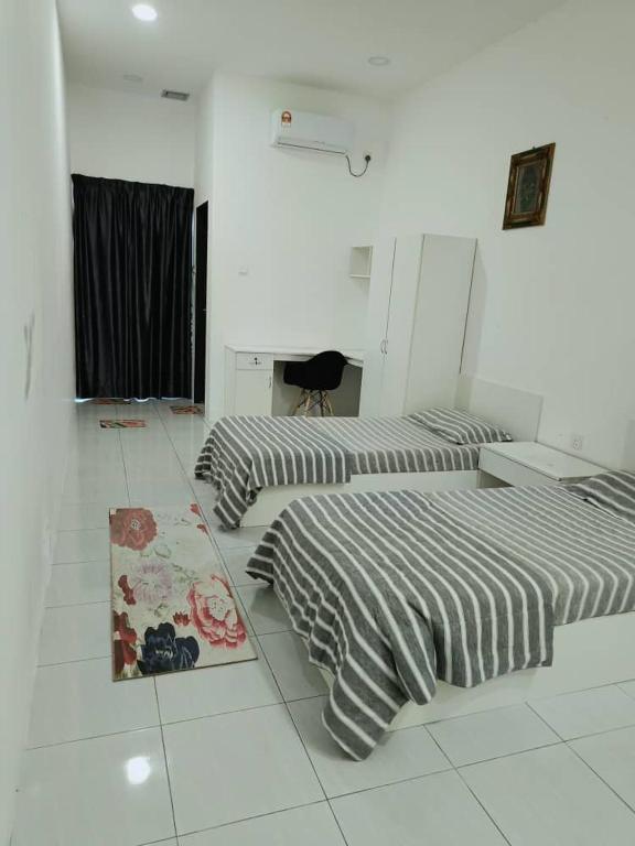 three beds in a white room with striped sheets at Soho Sri iskandar in Kampong Bota Road