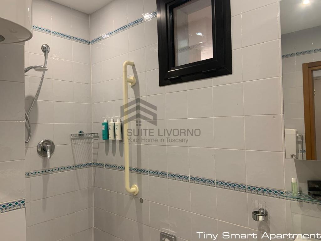 a bathroom with a shower with a mirror at Suites Marilia Apartments - Suite Livorno Holiday Home Group in Livorno