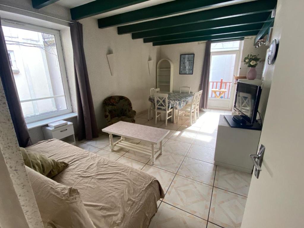 1 dormitorio con 1 cama y sala de estar con mesa en Residence Montlosier, en Le Mont-Dore