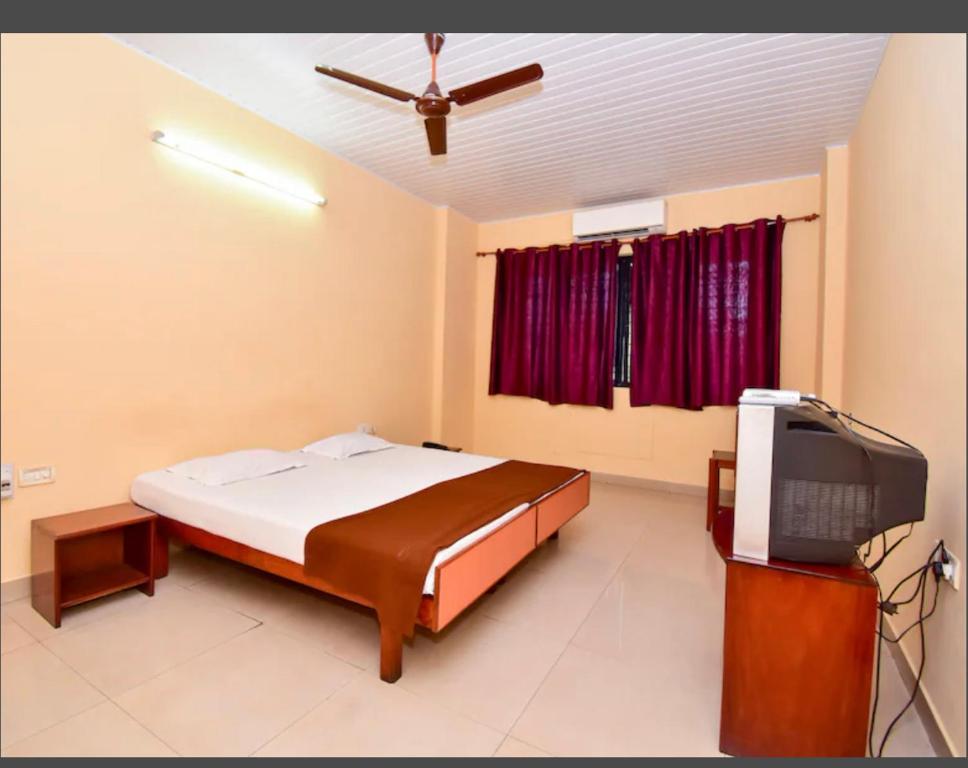- une chambre avec un lit et une télévision à écran plat dans l'établissement HOTEL ROYAL PARK, à Mangalore