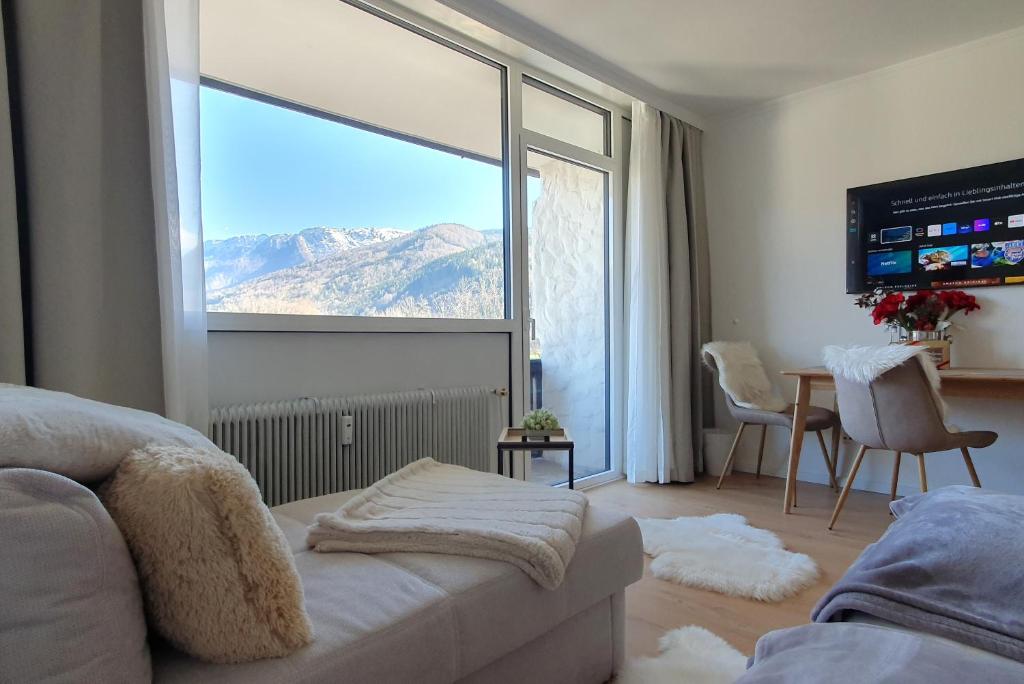 a living room with a large window with a mountain view at Bergblick 411 am Wolfgangsee in Strobl