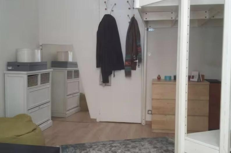 uma cozinha com armários brancos e um frigorífico branco em Belle chambre dans le quartier latin em Paris