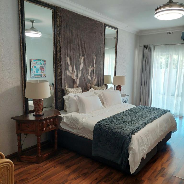 a bedroom with a large bed with a large mirror at Art and Soul Restaurant, Accommodation, French Bar and Art Gallery in Parys