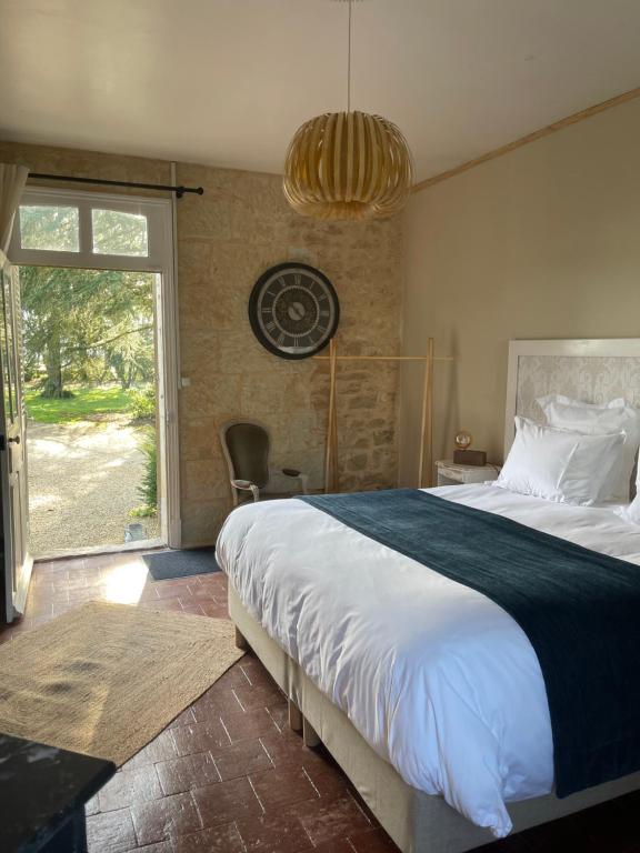 - une chambre avec un grand lit et une grande fenêtre dans l'établissement Le Château de Leugny, à Oiron
