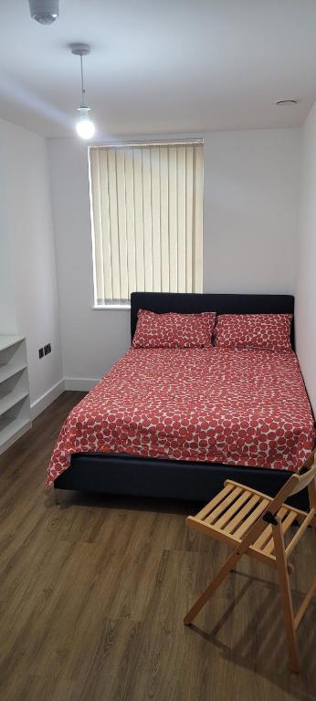 1 dormitorio con cama grande y silla de madera en Cosy Home en Londres