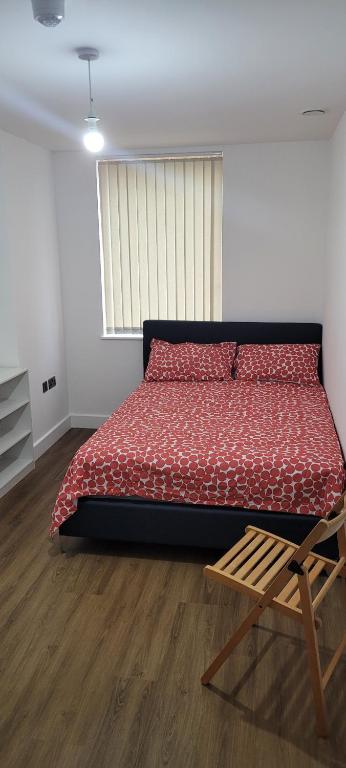 a bedroom with a large bed and a wooden chair at Cosy Home in London