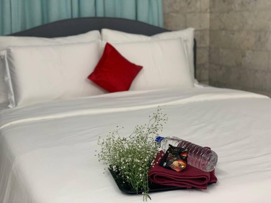 a bouquet of flowers and a bottle on a bed at Casa Quatro in Mumbai