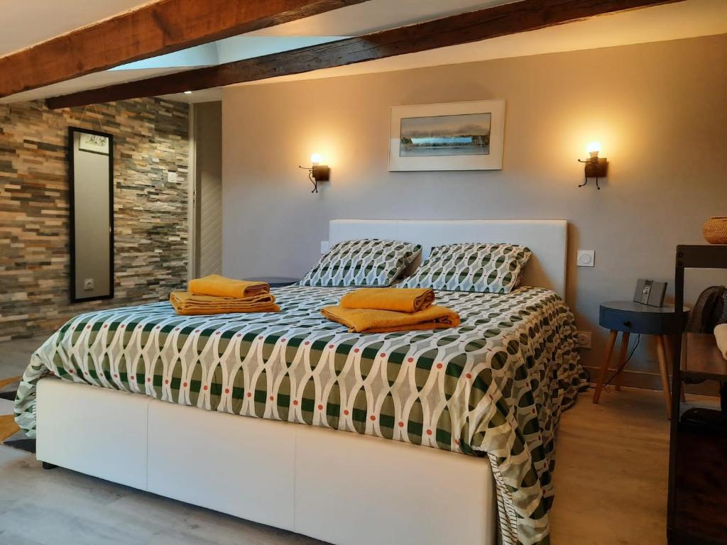 una camera da letto con un letto con cuscini arancioni sopra di Maison de charme avec terrasse et garage fermé proche des volcans a Royat