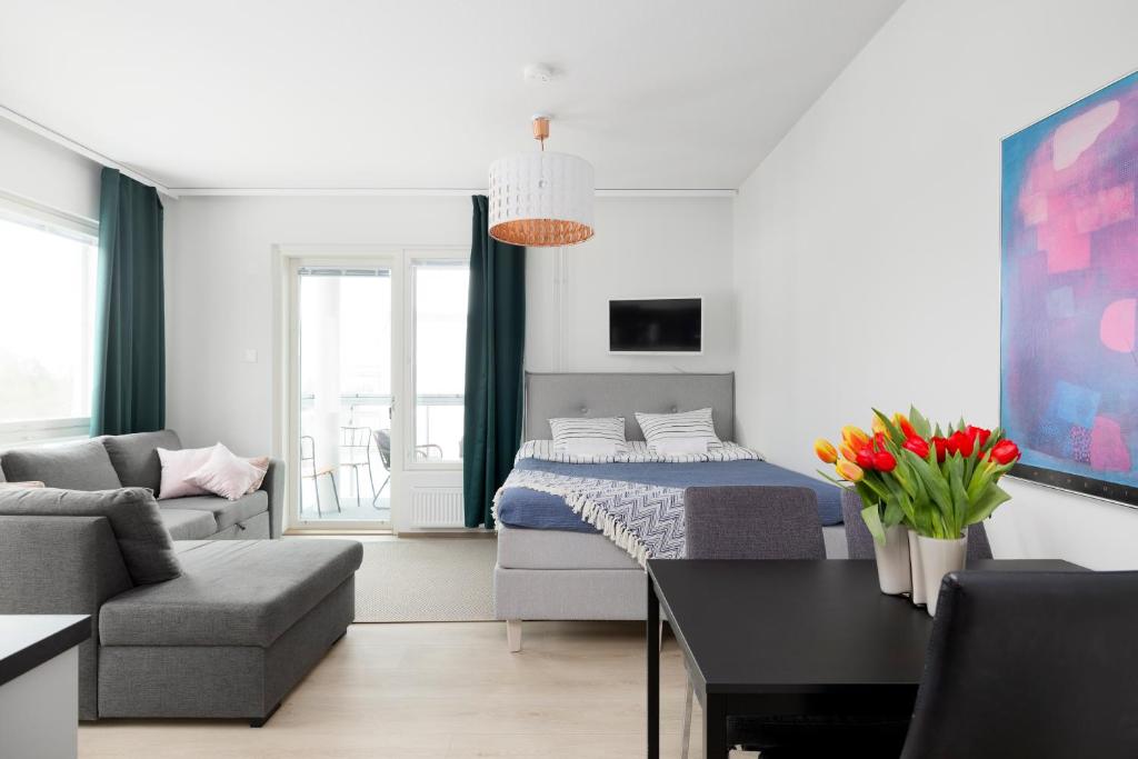 New 2BR design home with sauna Espoo Park في إسبو: غرفة نوم وغرفة معيشة مع سرير وأريكة