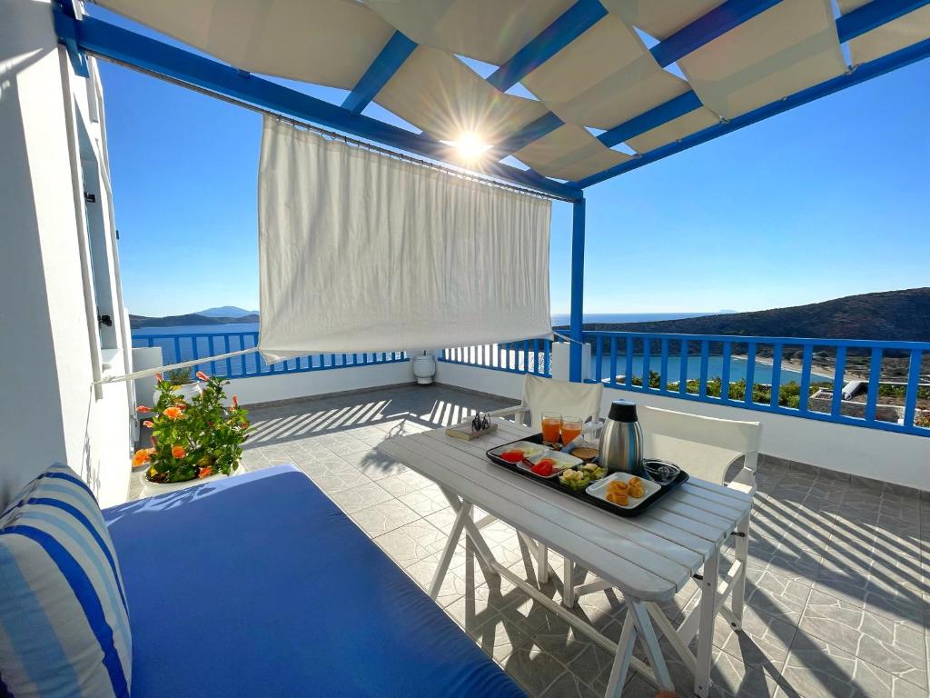 a table with a tray of food on a balcony at Villa Meltemi in Iraklia