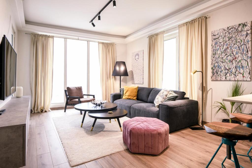 uma sala de estar com um sofá e uma mesa em Sky View Apartment at Cevahir Sky City 32nd floor em Skopje