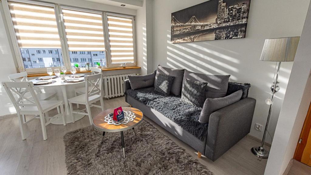 een woonkamer met een bank en een tafel bij VacationClub – Lwowska 2C Apartament 14 in Kołobrzeg
