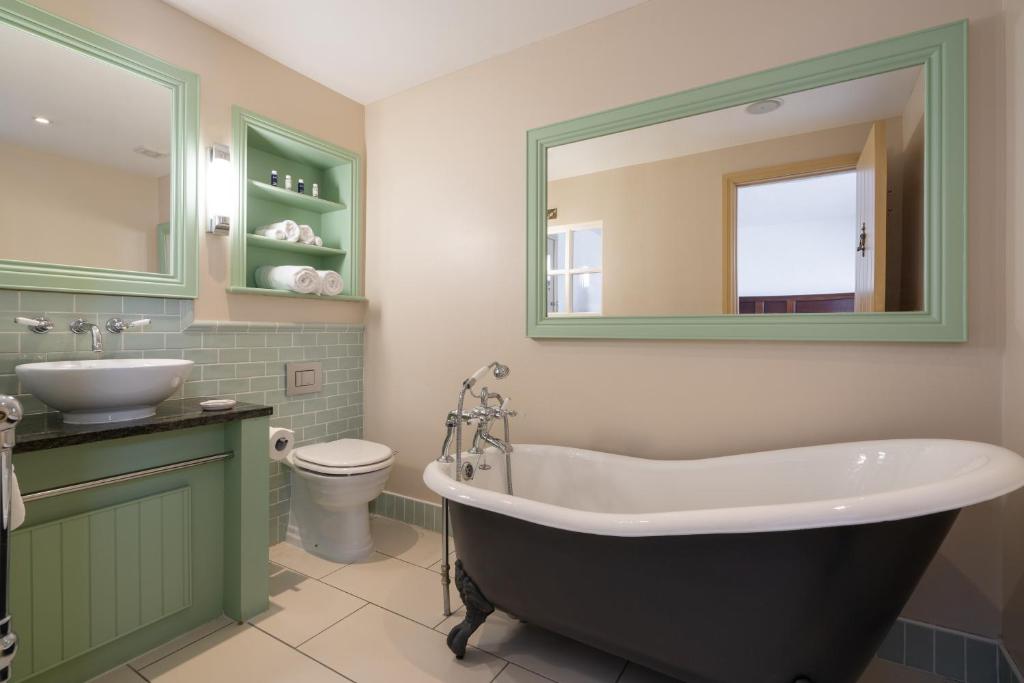 a bathroom with a tub and a sink and a toilet at Bushmills Inn Hotel & Restaurant in Bushmills