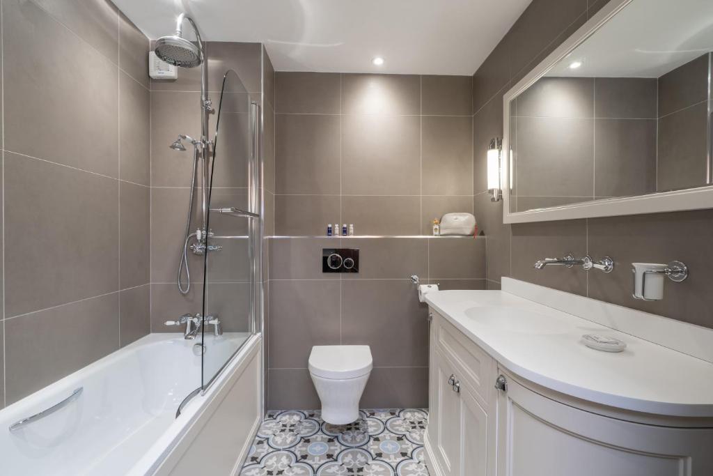 a bathroom with a tub and a toilet and a sink at Bushmills Inn Hotel & Restaurant in Bushmills