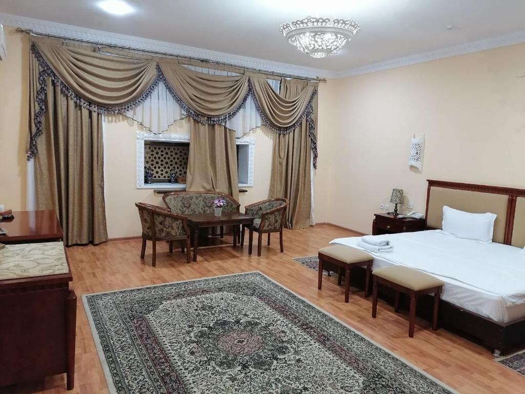 1 dormitorio con 1 cama y 1 mesa en una habitación en Sarbon Plaza Hotel, en Bukhara