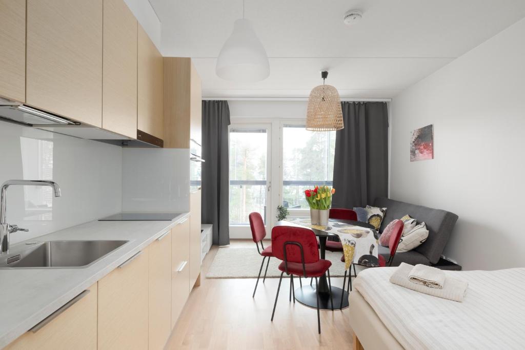 eine Küche und ein Wohnzimmer mit einem Tisch und Stühlen in der Unterkunft Sea View Design Studio near metro in Espoo