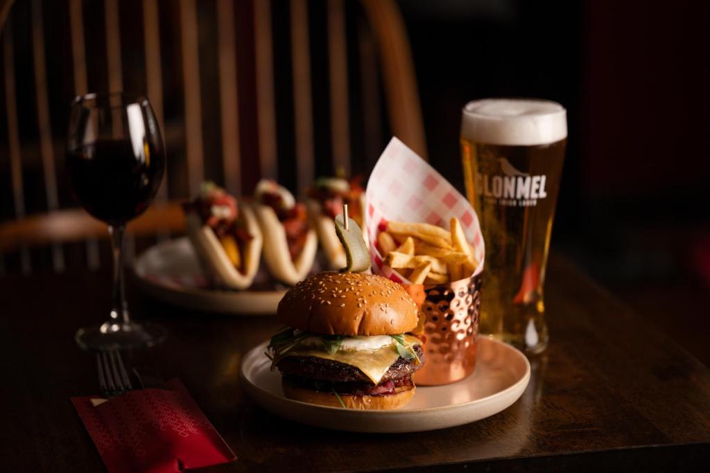 two plates with a hamburger and fries and a glass of beer at Bushmills Inn Hotel & Restaurant in Bushmills