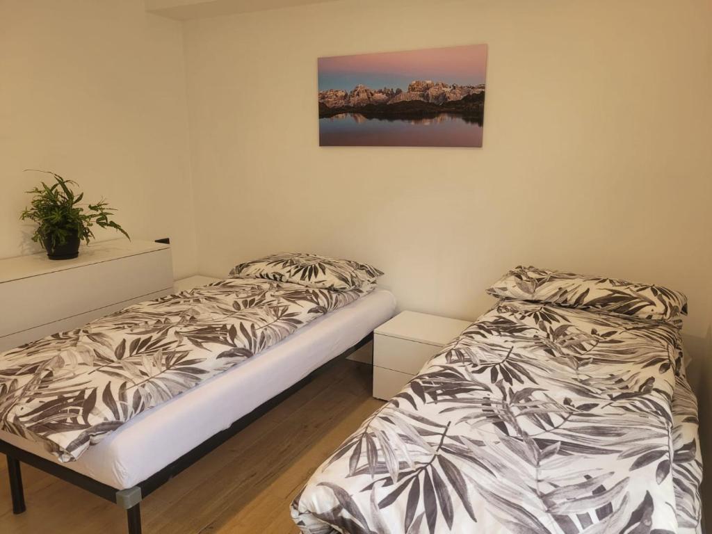 a bedroom with two beds and a picture on the wall at Apartment Sweet Retreat in Dro