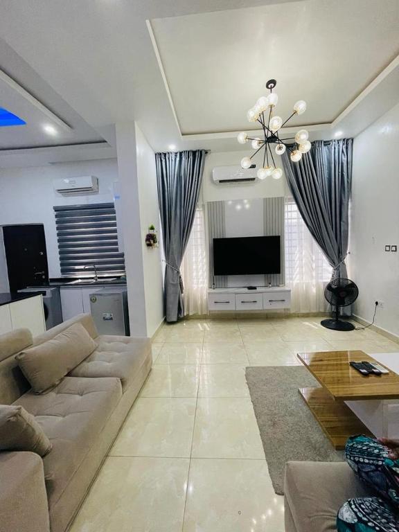 sala de estar con sofá y TV de pantalla plana en 4 bedroom Luxury Duplex en Lekki