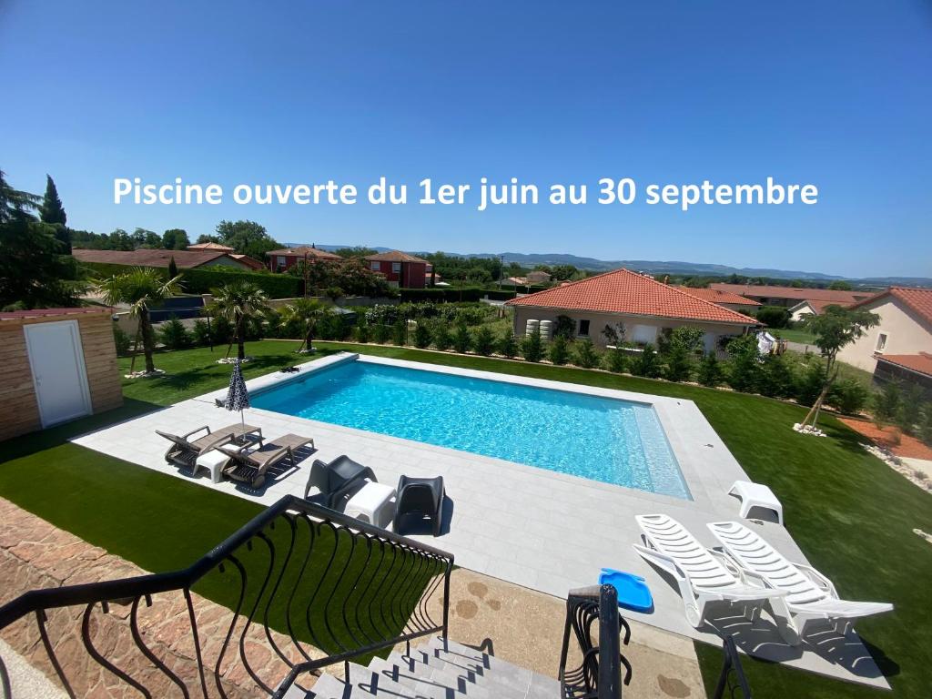 einen Pool in einem Garten mit Stühlen und einem Pool in der Unterkunft Logement indépendant chez l'habitant avec piscine commune in Grièges
