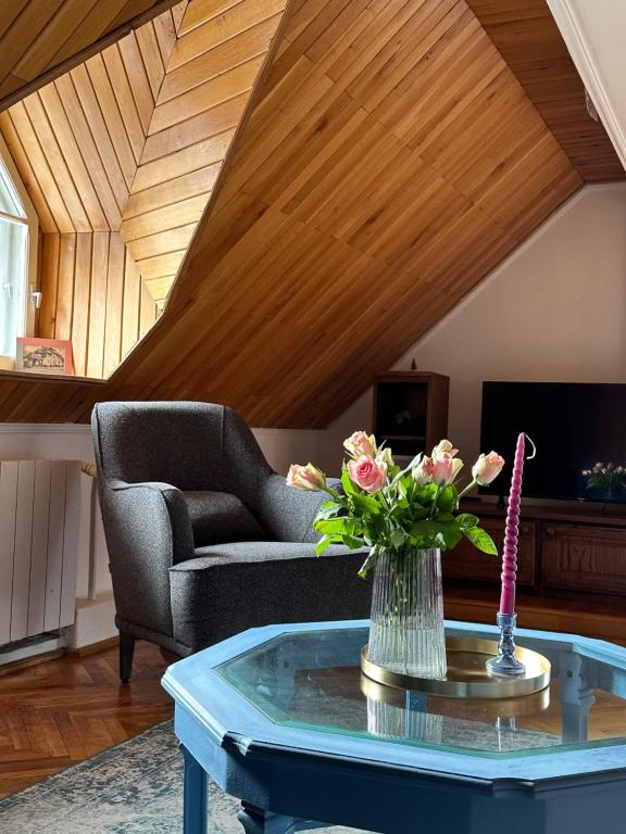 ein Wohnzimmer mit einem Sofa und einem Tisch mit Blumen in der Unterkunft Pine Peak Apartments in Predeal