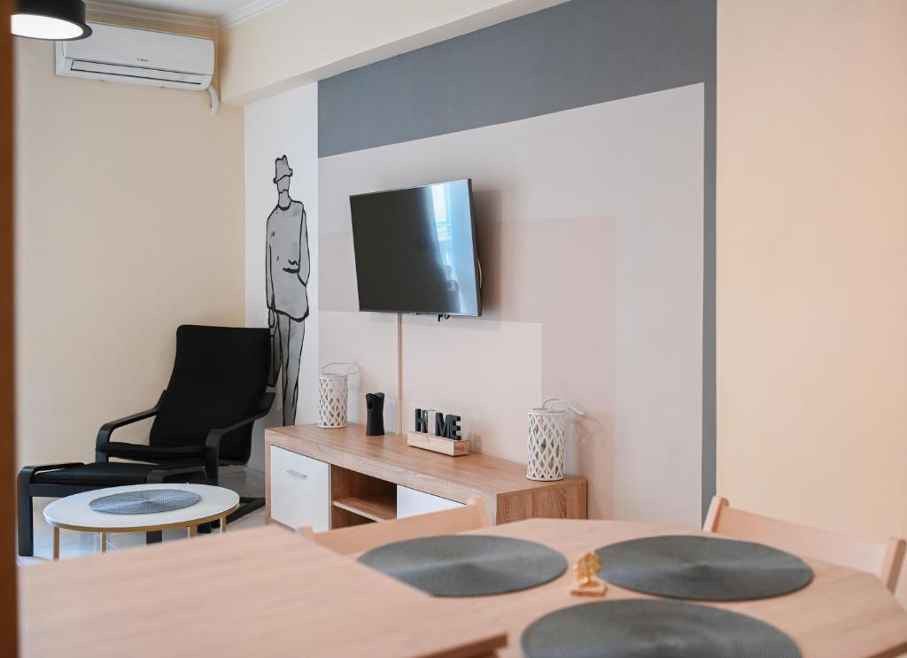 - un salon avec une table et une télévision murale dans l'établissement Kostas Home by Bill Apartments, à Patras