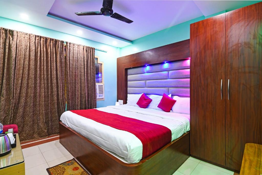 a bedroom with a large bed with red pillows at Hotel Ashray Near Temple & Beach By Morservices in Puri