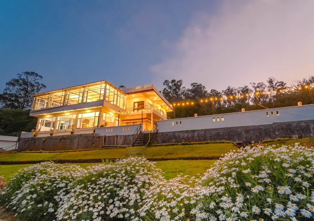 a large house is lit up at night at Silent Retreat Ooty Farm Resort by VOYE HOMES in Ooty