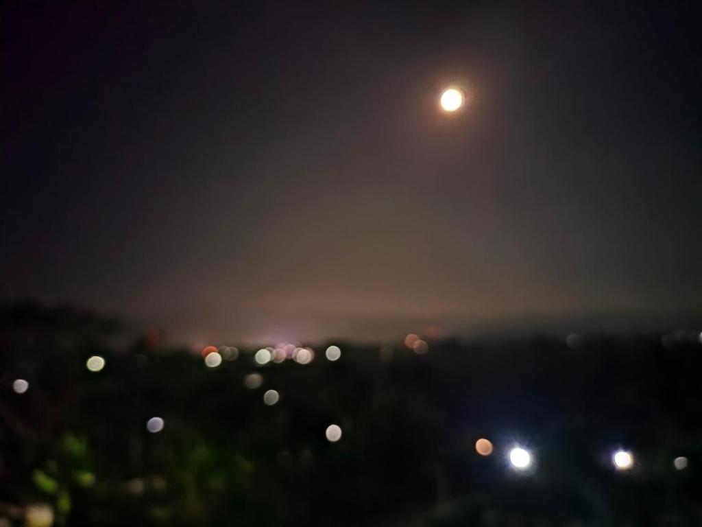 una vista de una ciudad por la noche con una luna en ระเบียงดอยโฮมสเตย์, en Wiang Pa Pao