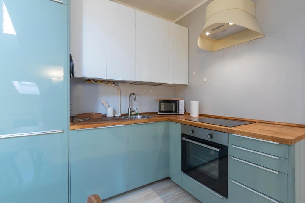 a small kitchen with blue cabinets and a sink at [IHost Apartment] - Adige 17 in Milan