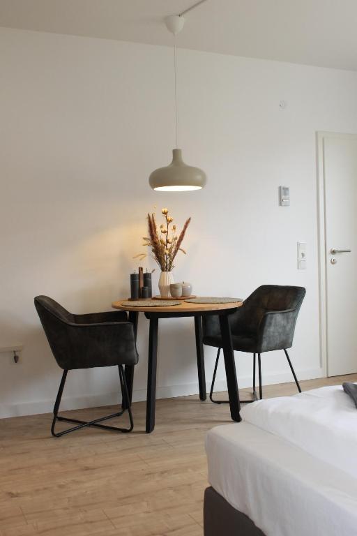 a table and two chairs in a room at Apartment mit 2 Betten in Flughafennähe in Paderborn