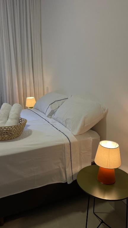 ein Schlafzimmer mit einem großen weißen Bett mit einer Lampe in der Unterkunft Apto JP 301 para 2 pessoas in Vitória