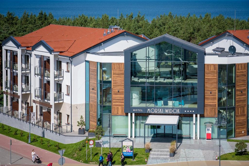 budynek z ludźmi idącymi przed nim w obiekcie Morski Widok w mieście Krynica Morska
