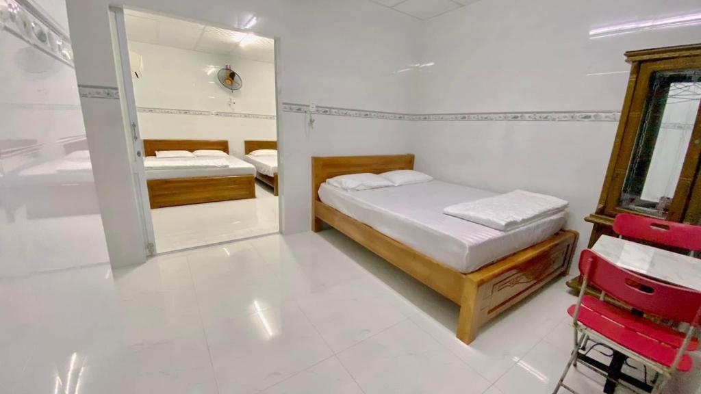 een kleine slaapkamer met twee bedden en een spiegel bij Nhà Nghỉ MỸ THUẬN in Long Hai