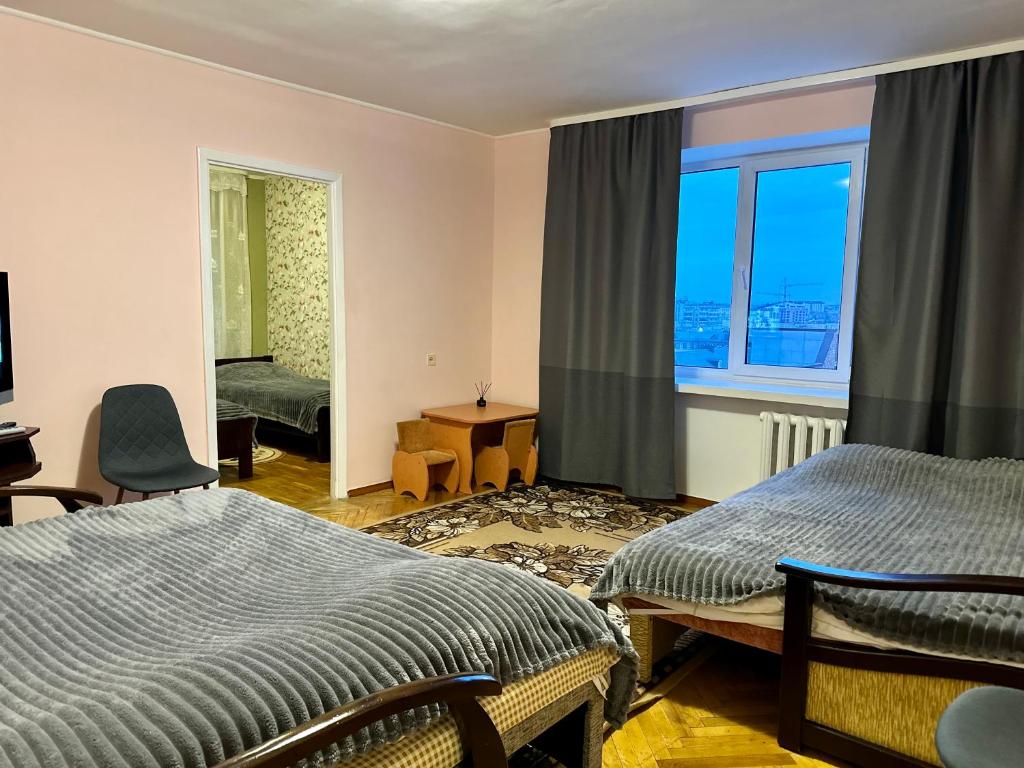 sypialnia z 2 łóżkami i oknem w obiekcie 4-км в центрі міста w mieście Rivne