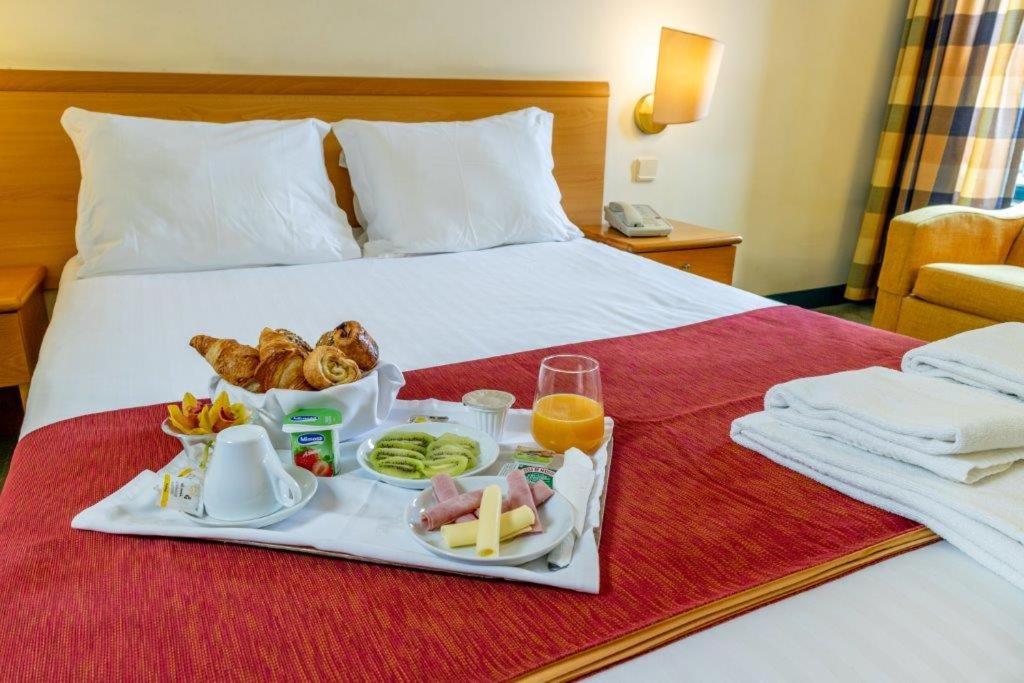 法菲的住宿－Flag Hotel Guimarães-Fafe，床上的托盘食物