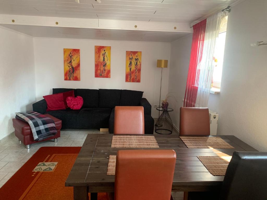 ein Wohnzimmer mit einem Tisch und einem Sofa in der Unterkunft Ferienwohnung-Schluecke in Bad Frankenhausen