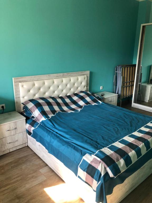 een bed in een slaapkamer met een blauwe muur bij Драхтик in Jerevan