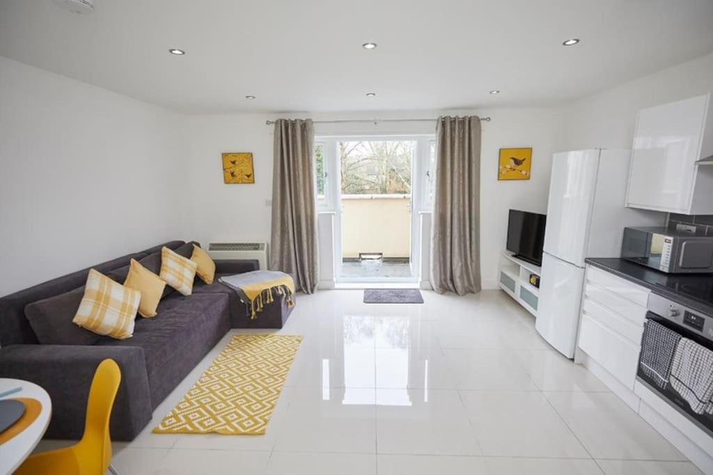 a living room with a couch and a kitchen at Spire View Apartment*SO15 Sleeps 4-Secure Parking in Southampton