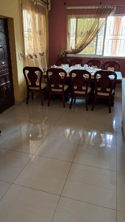 un comedor con mesa y sillas en una habitación en Berakah cozy Rentals, en Freetown