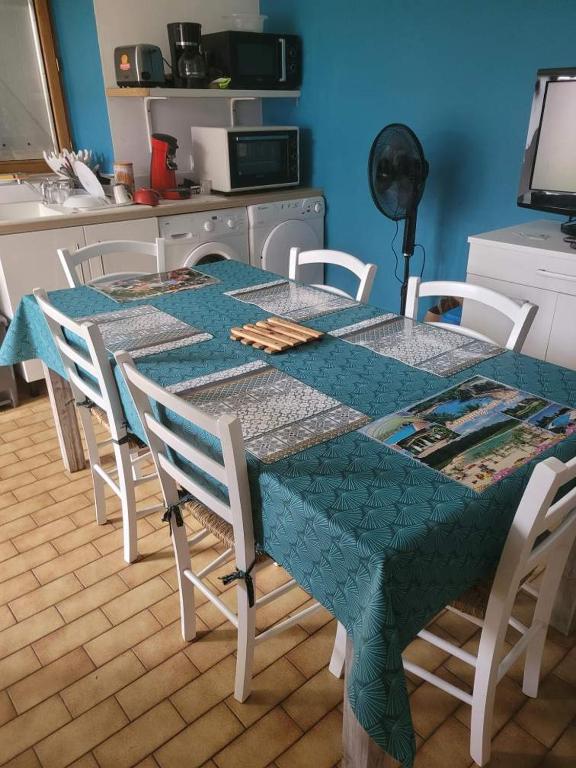 une table avec des chaises et un chiffon de table bleu dans l'établissement Gite le Nid de l'Erdre, à La Pouëze