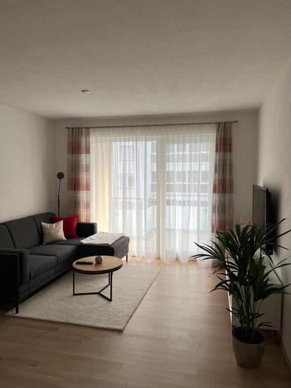 ein Wohnzimmer mit einem Sofa und einem Tisch in der Unterkunft Ferienwohnung MiKa in Friedrichshafen