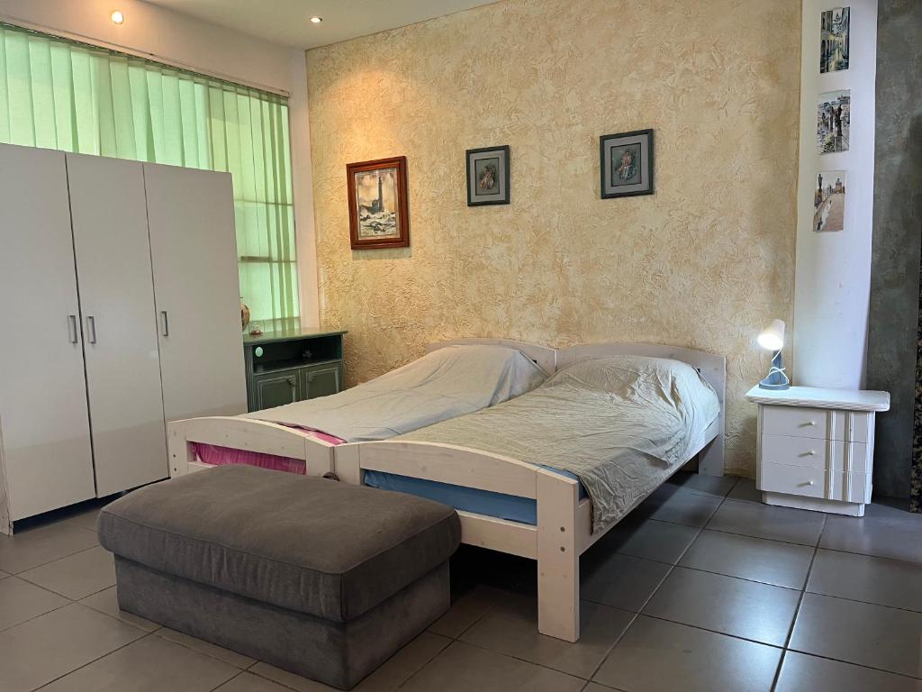 a bedroom with a bed and a ottoman in it at Local 3 Puerto Colon First Line The Loft Coworking Suite in Adeje
