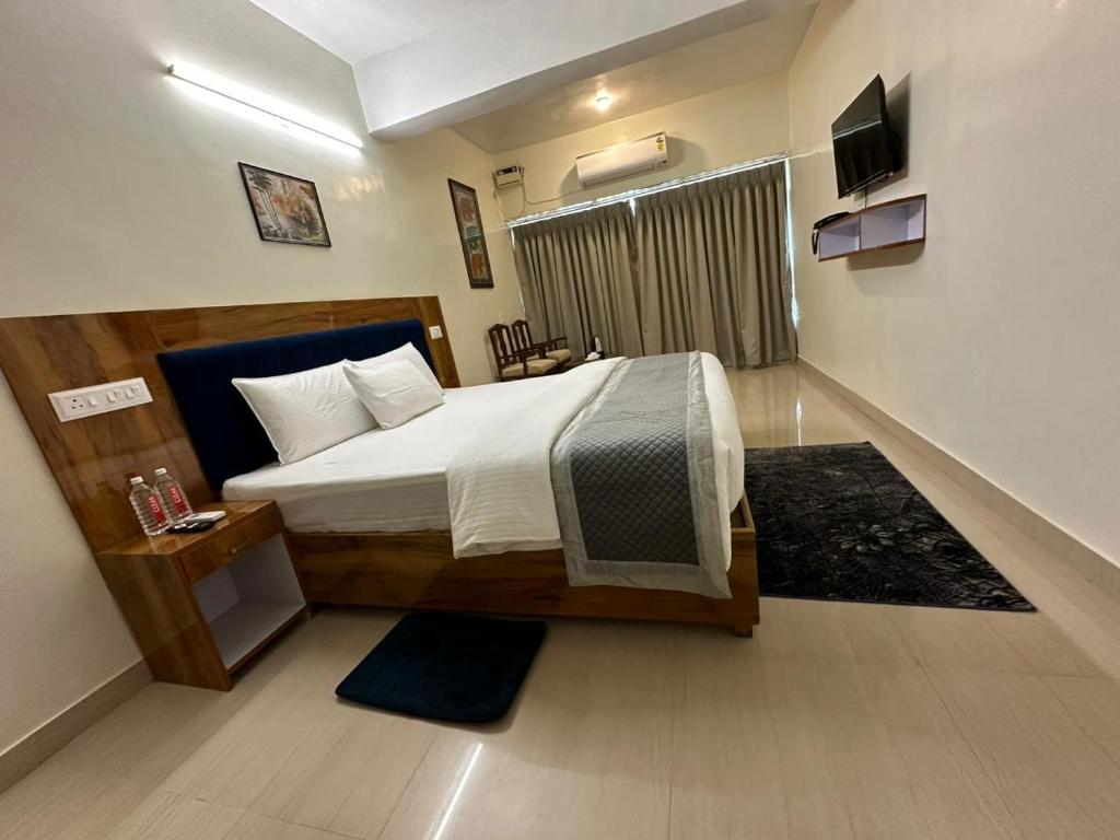 a bedroom with a large bed in a room at HOTEL DADO'S INN in Panaji
