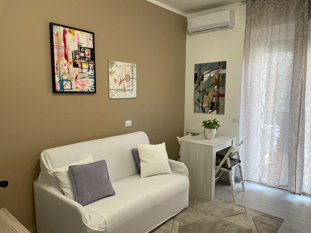 a living room with a white couch and a table at Crescenzago#34, vicino Metro M2 e Ospedale San Raffaele in Milan
