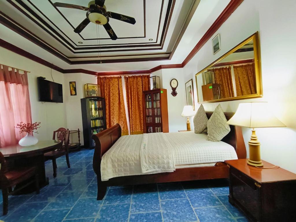 sypialnia z łóżkiem, biurkiem i sufitem w obiekcie Negros Haven Seaside Resort w mieście Jayugan