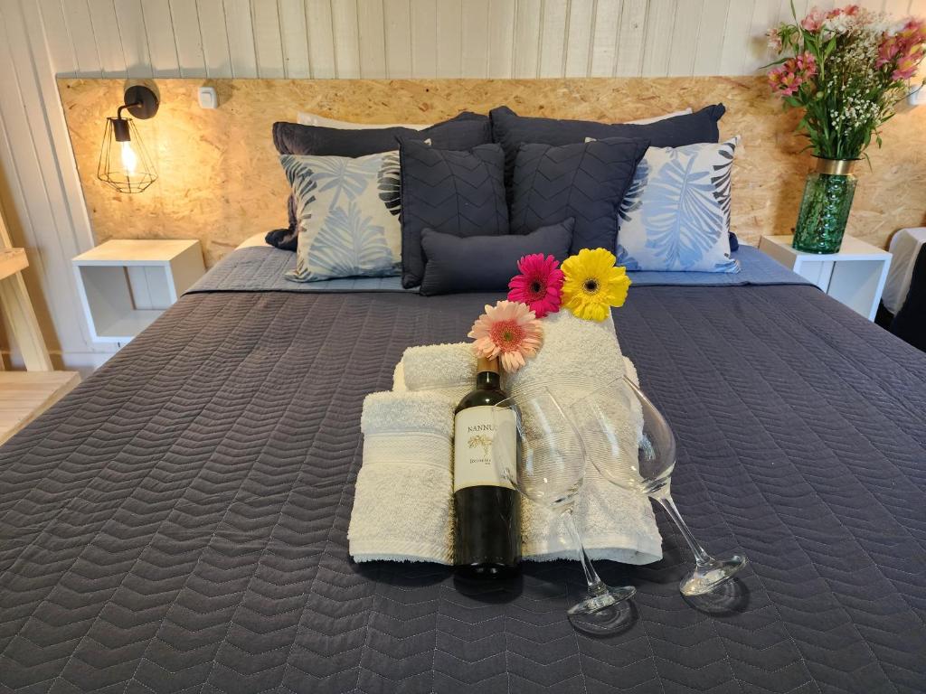 Una cama con una botella de vino y flores. en Casa Aqua hotel boutique en Mendoza