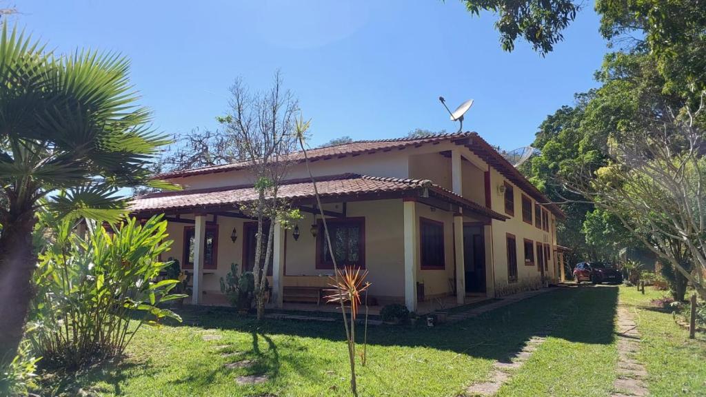 uma casa com uma turbina eólica em cima dela em Fazenda Santa Luzia em Além Paraíba