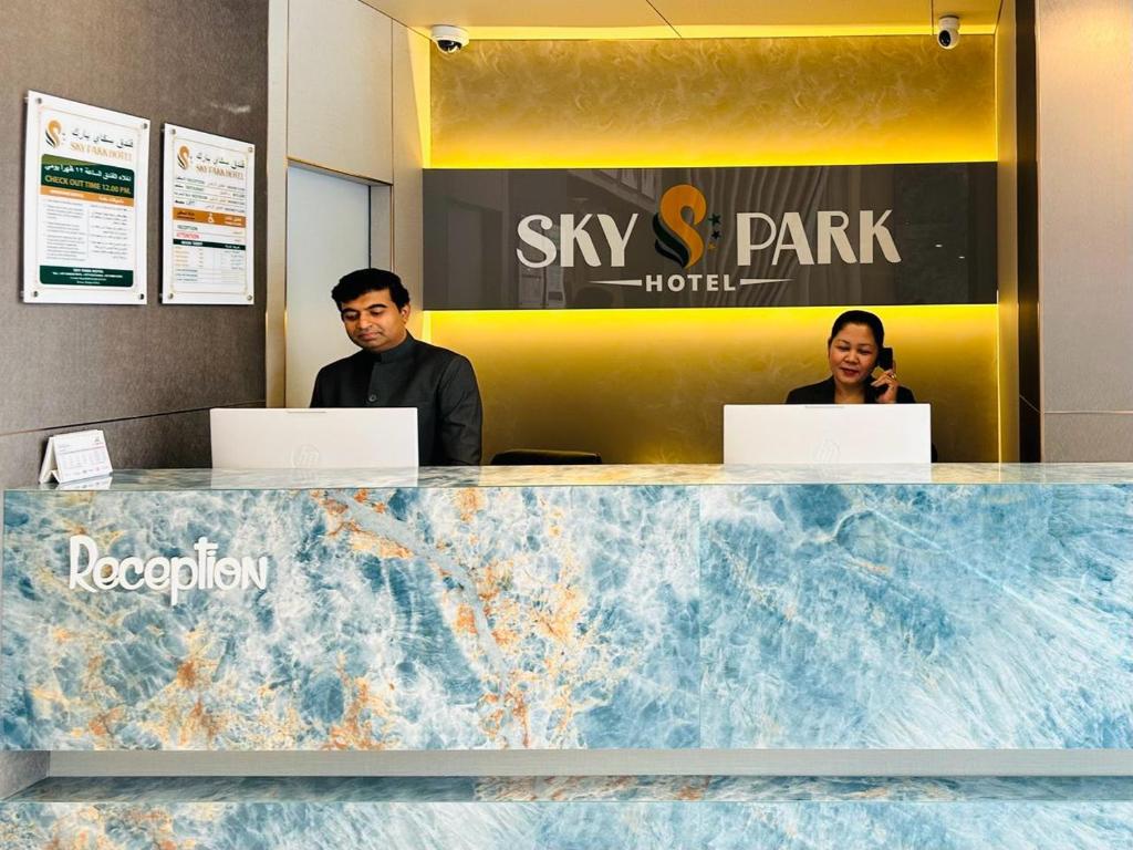 two people sitting at a desk with their laptops at SKY PARK HOTEL in Dubai